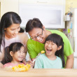 happy family and daughter eating fruits in the kitchen happy family and daughter eating fruits in the kitchen